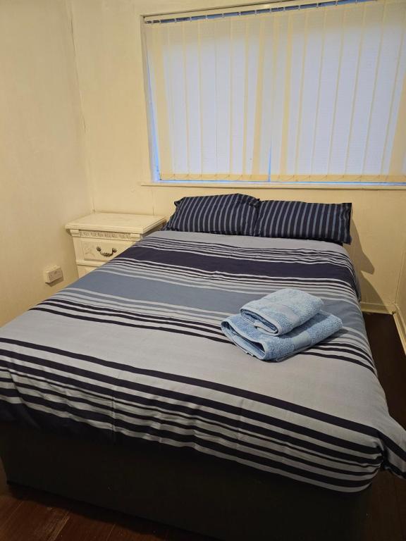 Una cama con dos toallas encima. en Axel room 2, en Mánchester