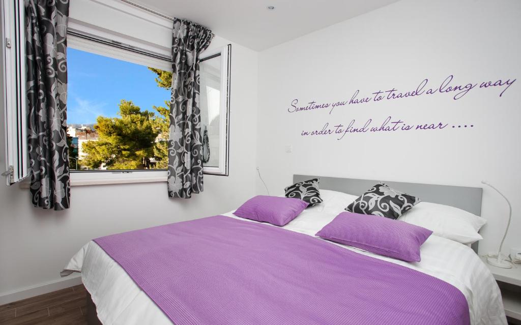 Un dormitorio con una cama con sábanas moradas y una ventana en Apartment 4 You in Split, en Split