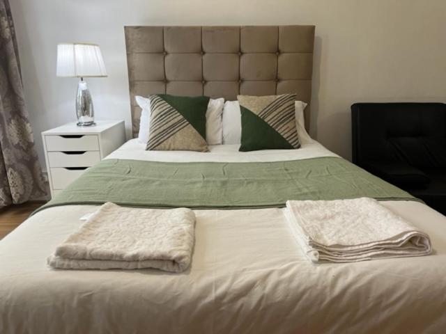 sypialnia z dużym łóżkiem z dwoma ręcznikami w obiekcie Ensuite With Kitchen Ext Large Room With Balcony in Zone 2 w Londynie