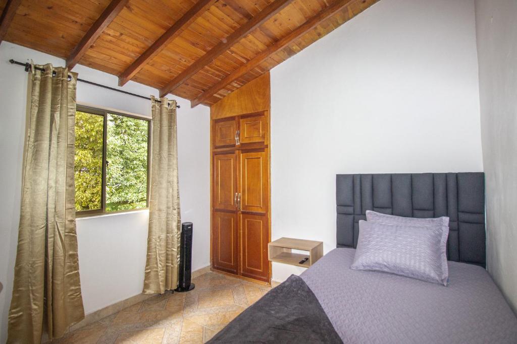 um quarto com uma cama e uma janela em Apartamento a 3 min del Hospital Pablo tobón uribe em Medellín