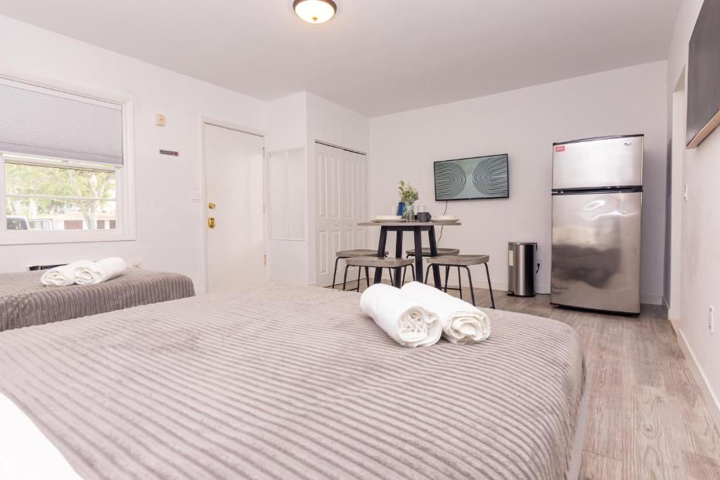 a white room with two beds and a table at Studio Las Olas Beach - Fort Lauderdale - 5 minutes walk to beach in Fort Lauderdale