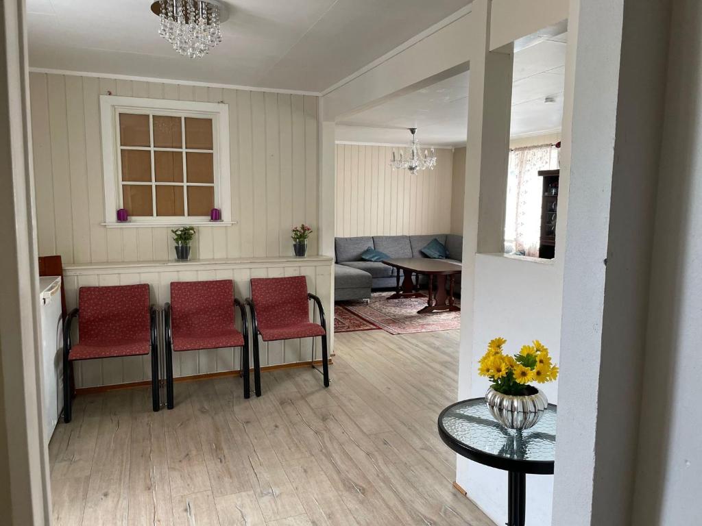 a living room with red chairs and a table at Koselig og stor enebolig til leie i Arendalsuke / ferie in Arendal