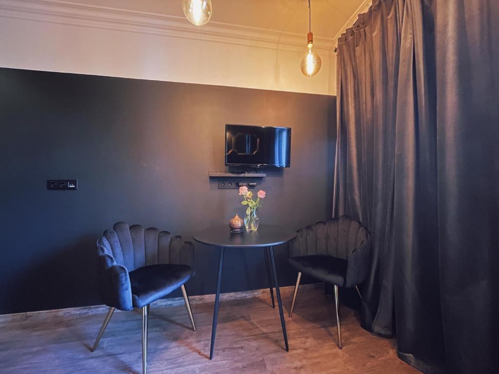 um quarto com uma mesa e duas cadeiras e uma televisão em Central & Functional Studio Riga em Riga