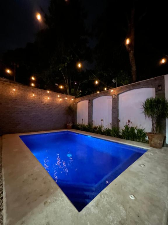 a swimming pool in a backyard at night at Casa Encanto Luz del Mar, Con Piscina Privada in Herradura