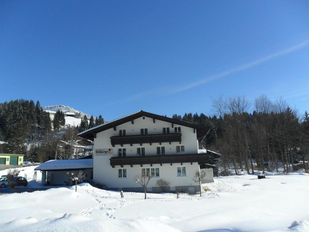 a large white building in the snow at Gästehaus Walpurga in Russbach am Pass Gschütt