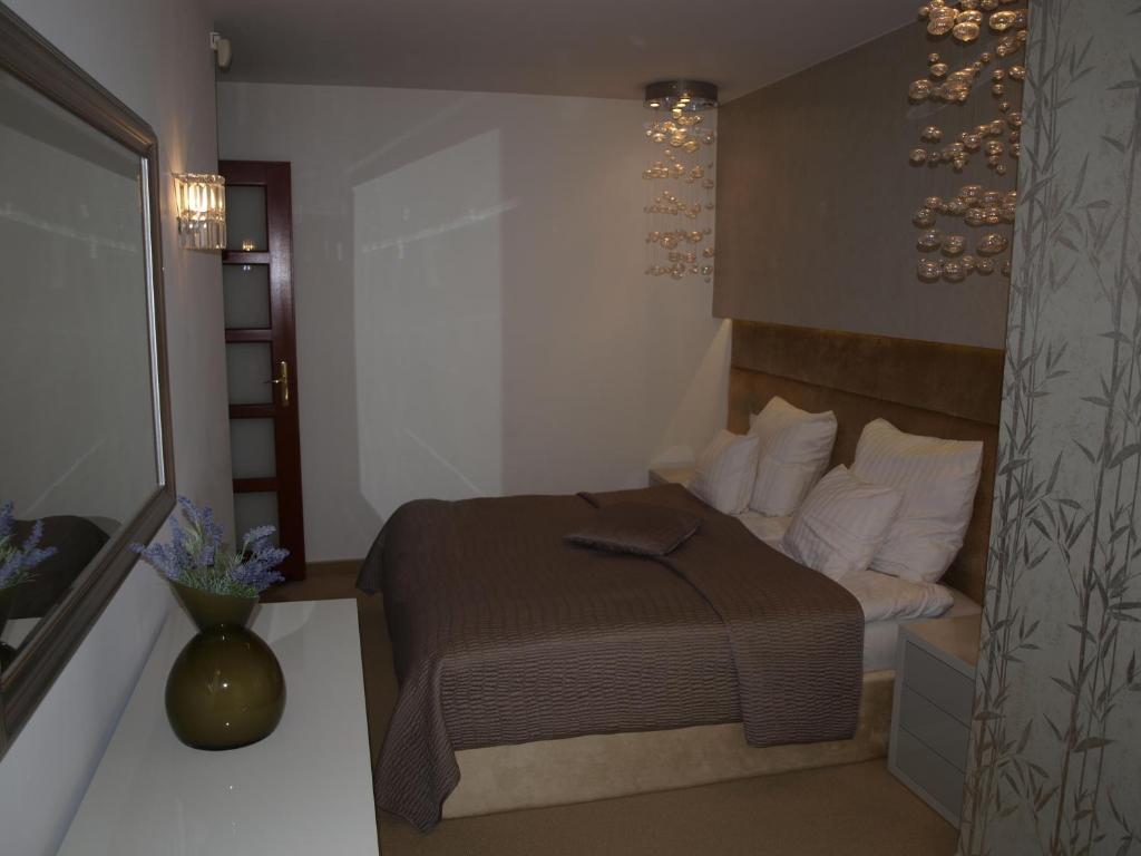 ein Schlafzimmer mit einem Bett und einer Vase mit Blumen in der Unterkunft Apartament Sea Towers in Gdynia