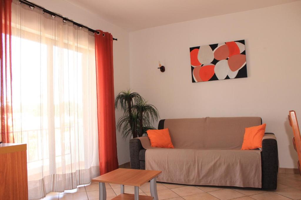 a living room with a couch and a window at Dinita Apartamentos in Albufeira