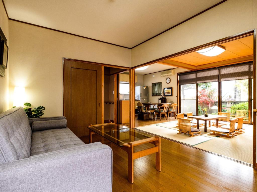 een woonkamer met een bank en een tafel bij Yanagi-an in Kameoka