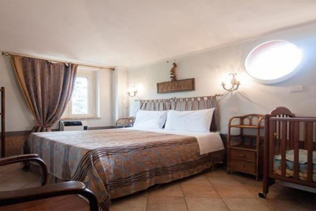 1 dormitorio con cama, ventana y cuna en Charming Villa with swimming pool-Todi, Italy, en Todi