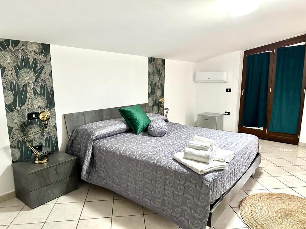 een slaapkamer met een bed met groene kussens erop bij B&B Cloe in Scafati