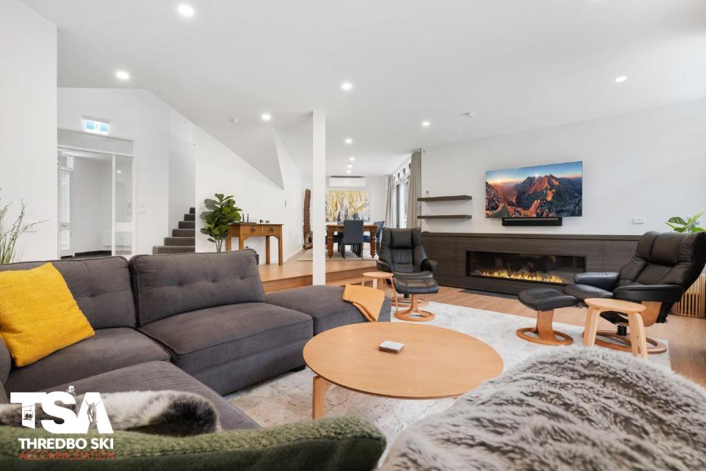 a living room with a couch and a fireplace at Chalet 26 in Thredbo