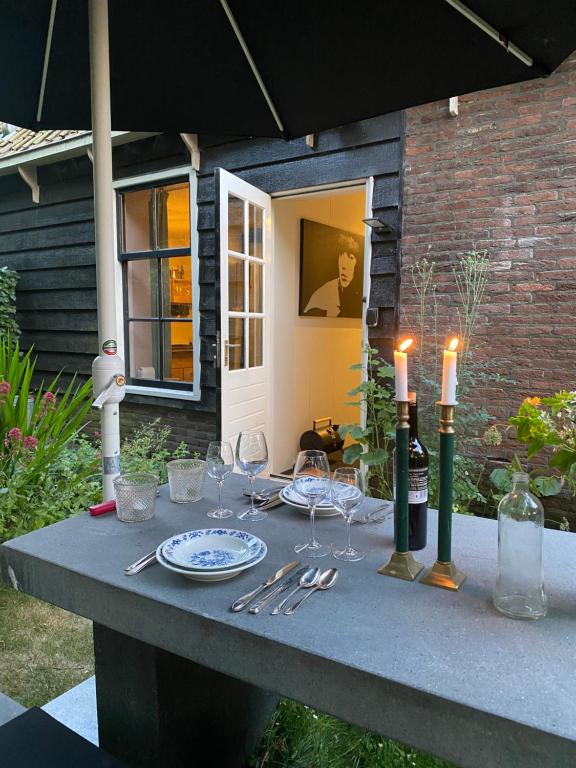 una mesa con copas de vino y velas en Ingeborgh Art Gastenverblijf, en Grootschermer