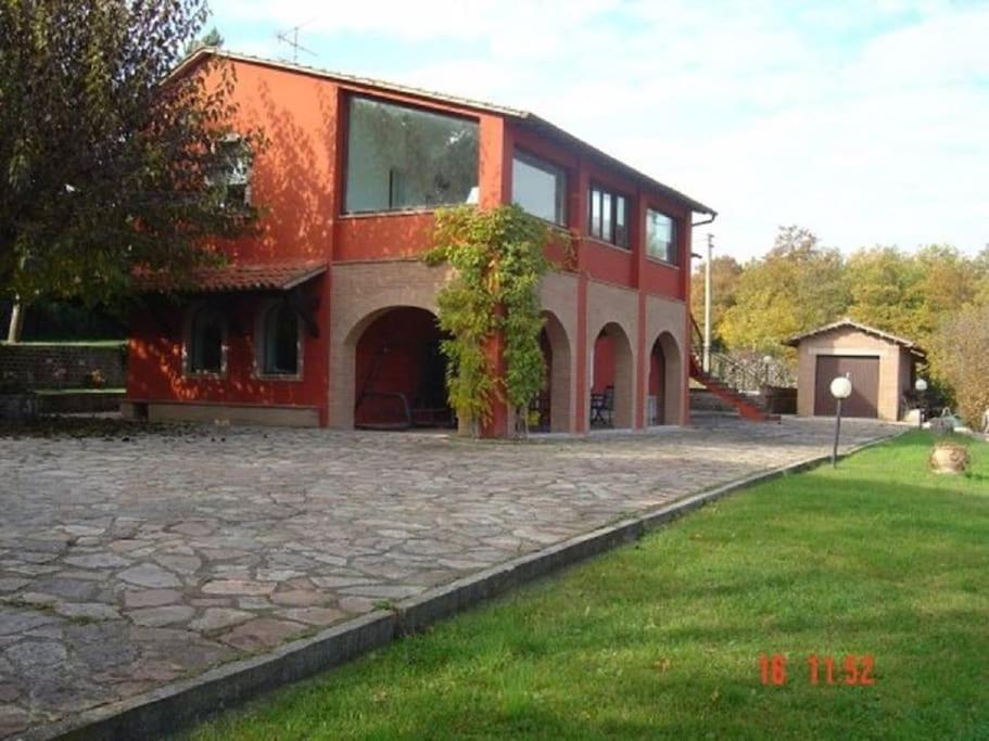 una grande casa rossa con un vialetto in pietra di Self catering Villa with pool in Umbria, Italy a Todi