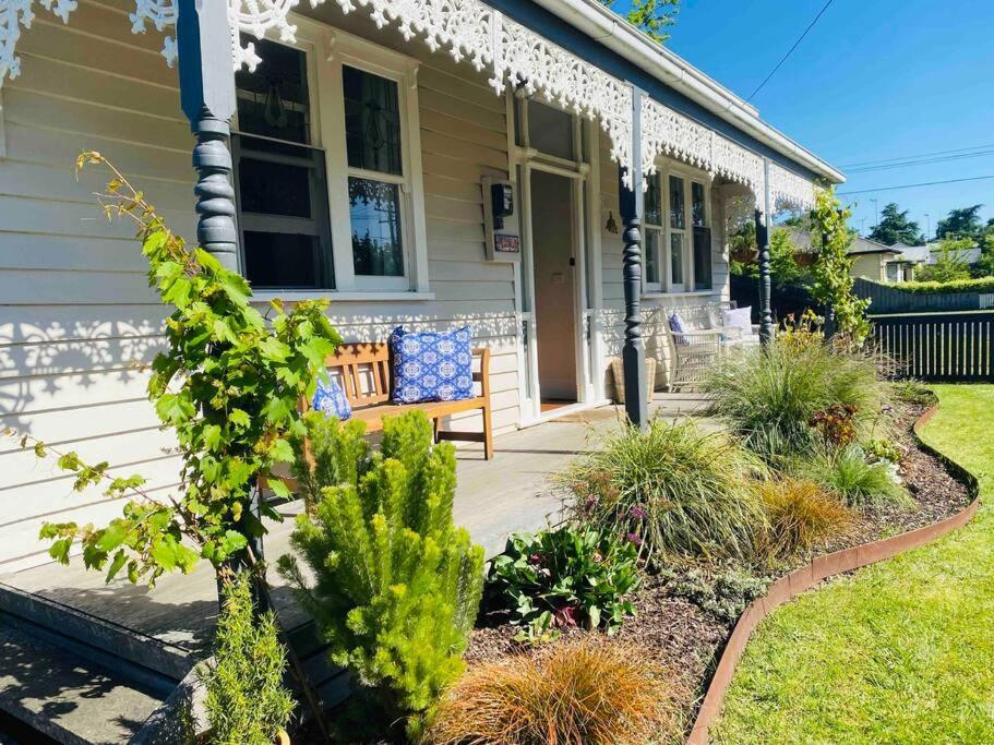 a house with a bench on the front porch at Mena-close to Ballarat CBD, self check-in with bath and cot in Ballarat