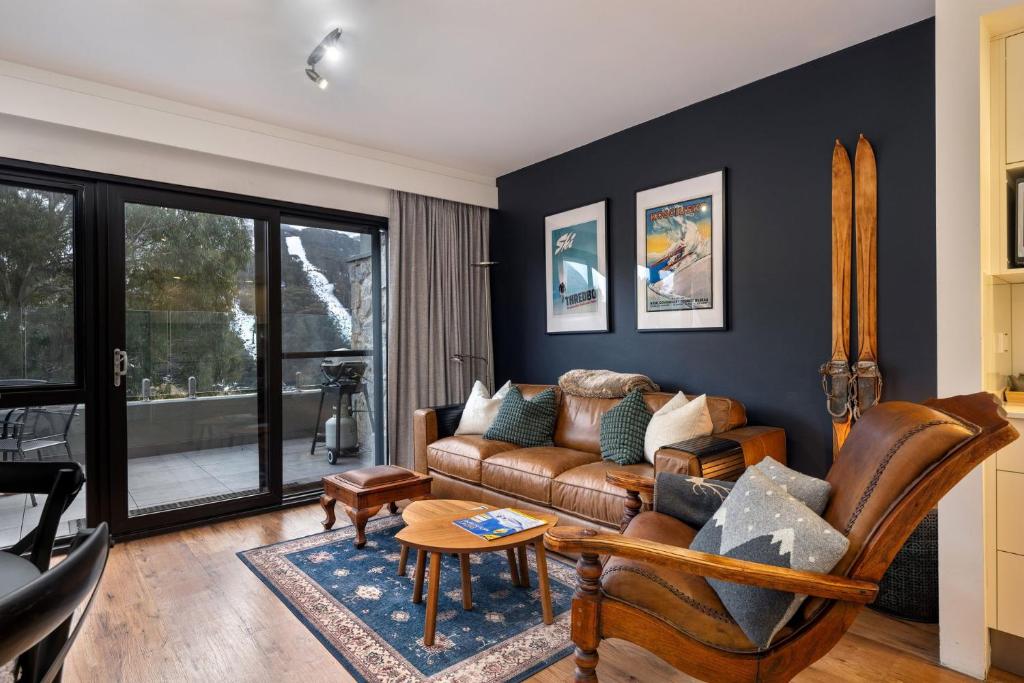 a living room with a couch and a table at Lantern 1 Bedroom Deluxe with hot tub and car park in Thredbo