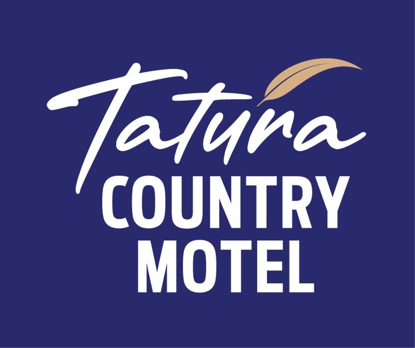 Tatura Country Motel في Tatura: علامة تقول فندق تيانا ريفي مع مظلة