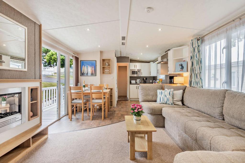 sala de estar con sofá y mesa en Maple Brook Lodge Sea Breeze Shorefield, en Lymington