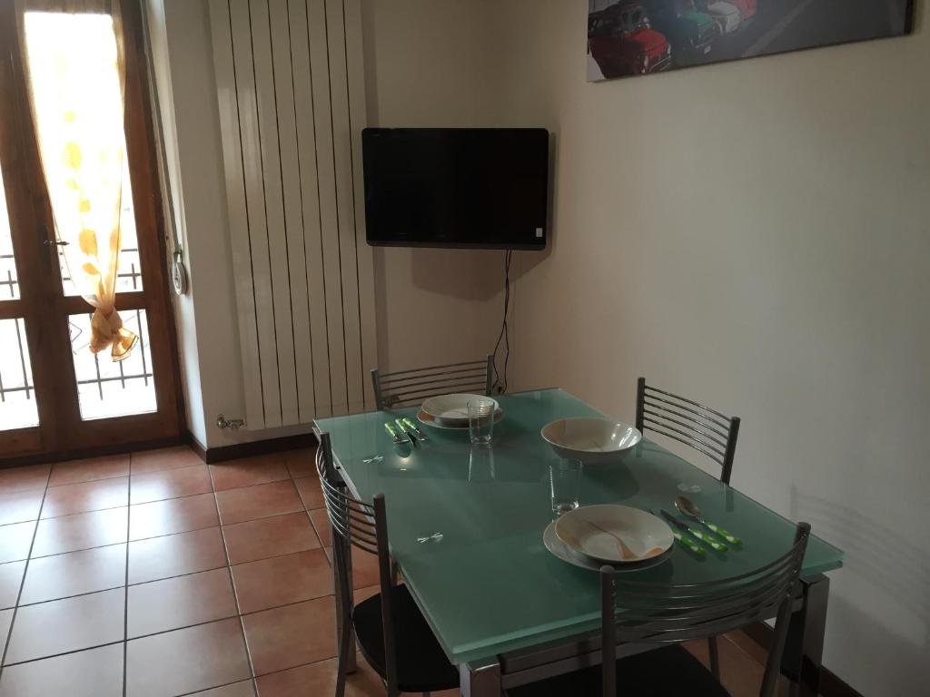 a green dining room table with chairs and a television at Grazioso Trilocale Centro/Stazione in Brescia