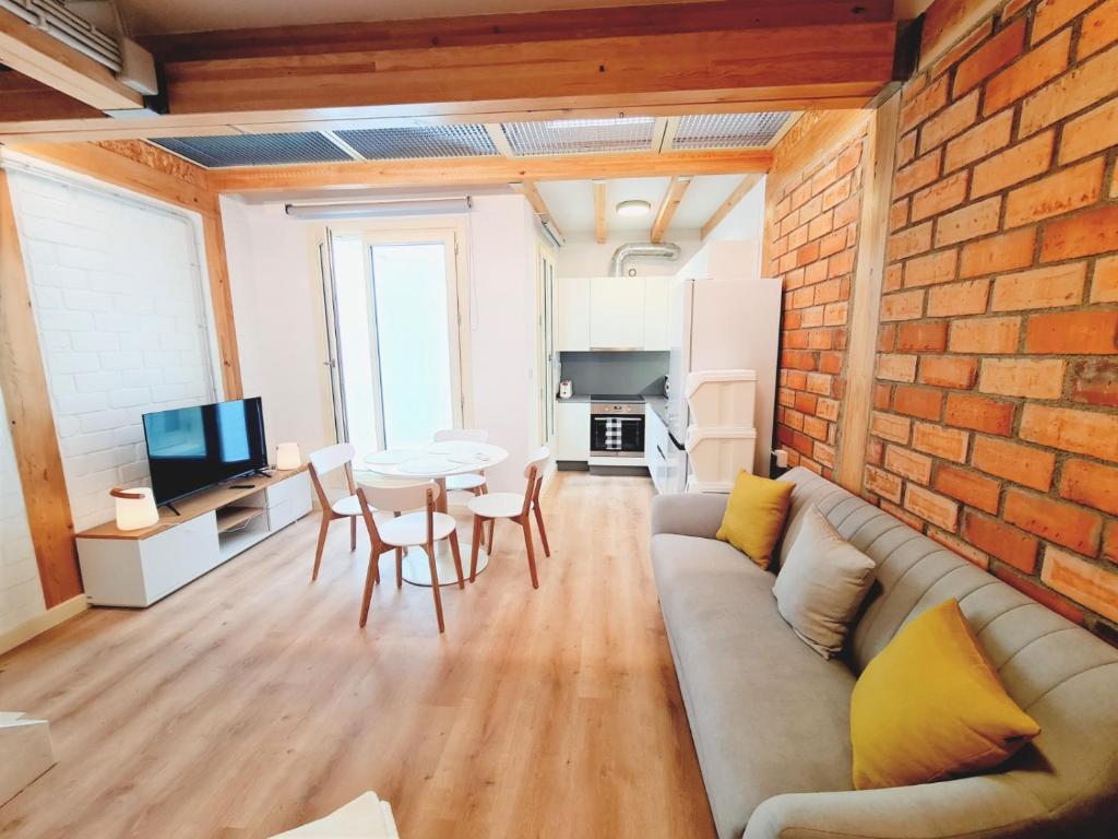 a living room with a couch and a brick wall at Edificio Amalia Rosina 4ºB in Ourense