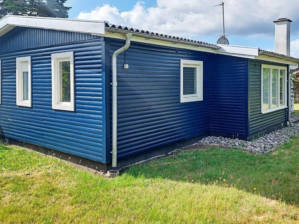 a blue house with two windows on the side of it at Holiday home Karrebæksminde LIV in Karrebæksminde