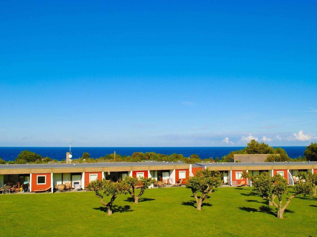 a building with trees in the middle of a field at 6 person holiday home in Allinge in Allinge