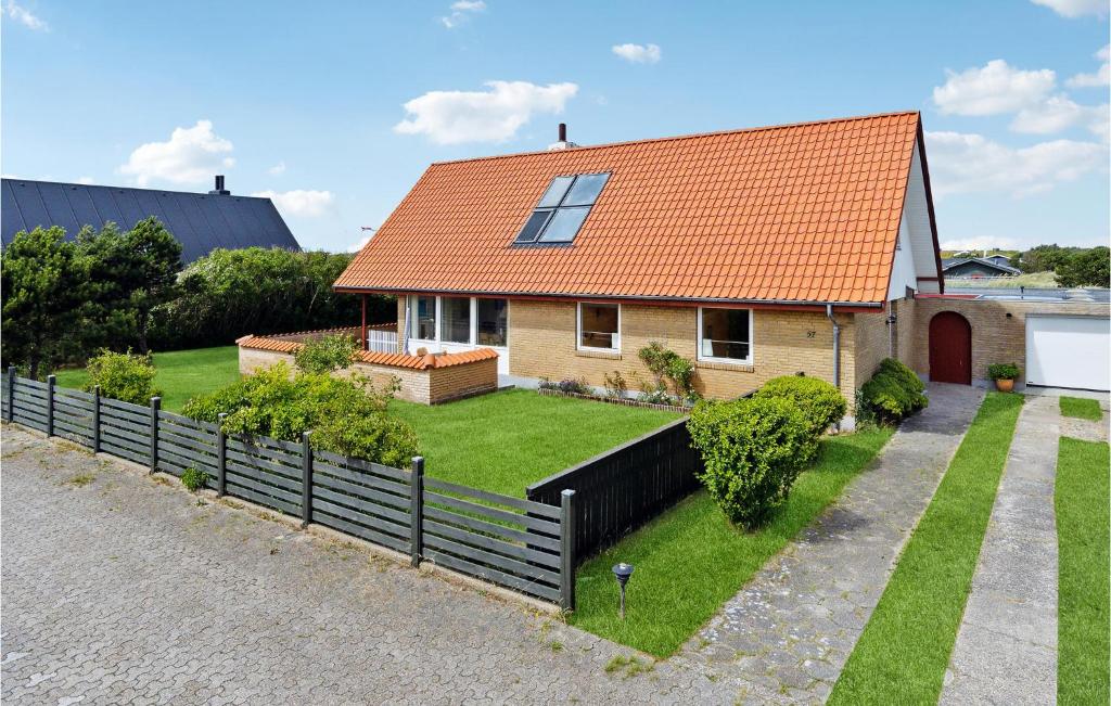 a house with an orange roof and a fence at 3 Bedroom Stunning Home In Skagen in Skagen