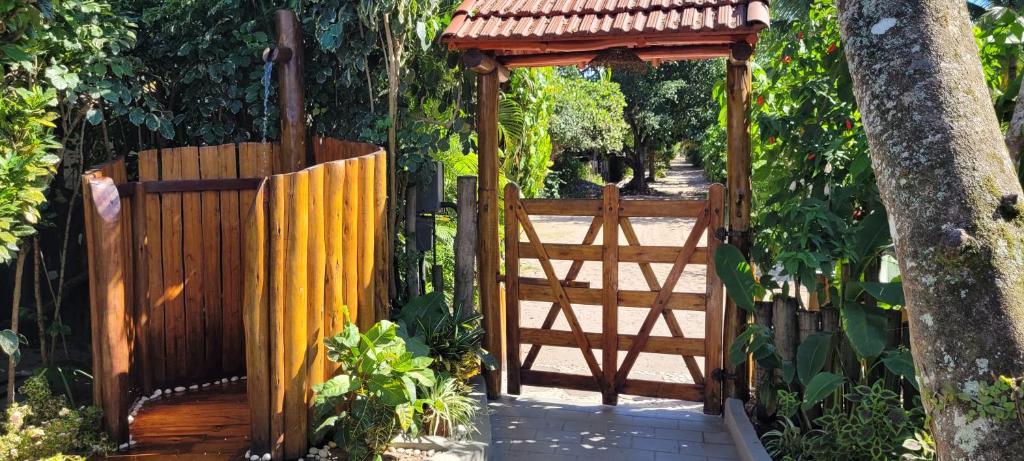 uma entrada para um portão de madeira com um gazebo em Pousada NÔ Caraíva em Caraíva
