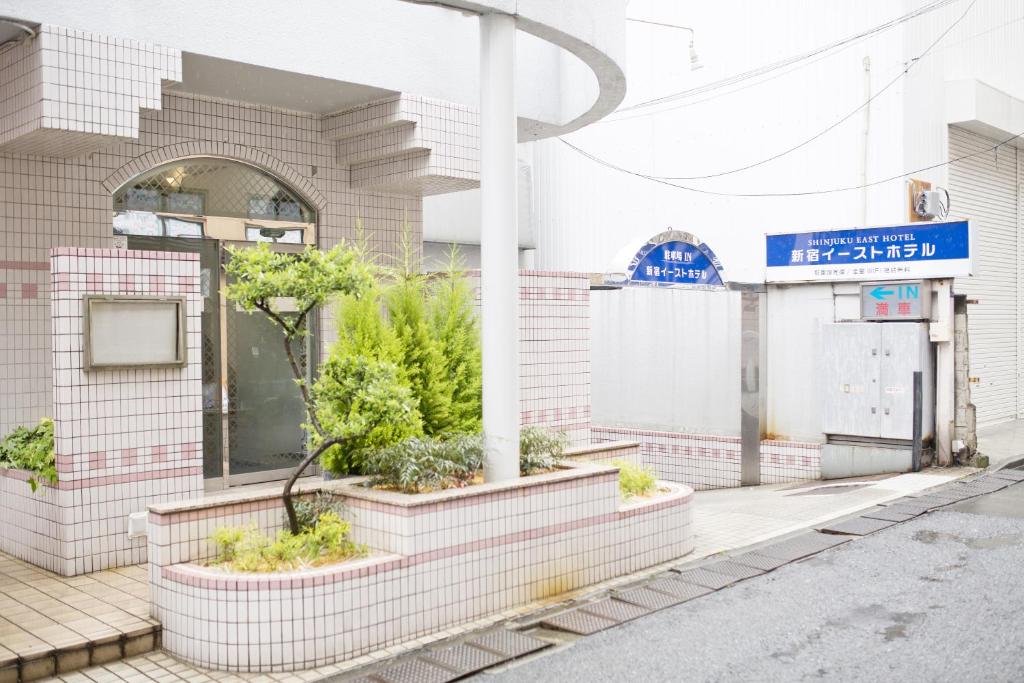 東京的住宿－東新宿酒店，街道边有植物的建筑