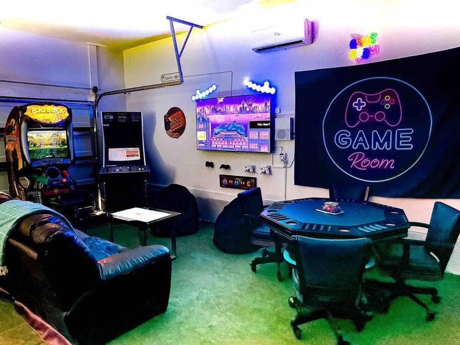 um quarto com uma sala de jogos com uma mesa e cadeiras em 5 Star 4/3 sleeps 16 with Arcade GAME ROOM & POOL! em Orange Beach