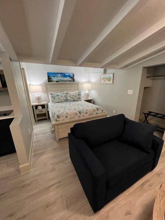 a bedroom with a bed and a couch in it at Tarpon Tale Inn in Sanibel