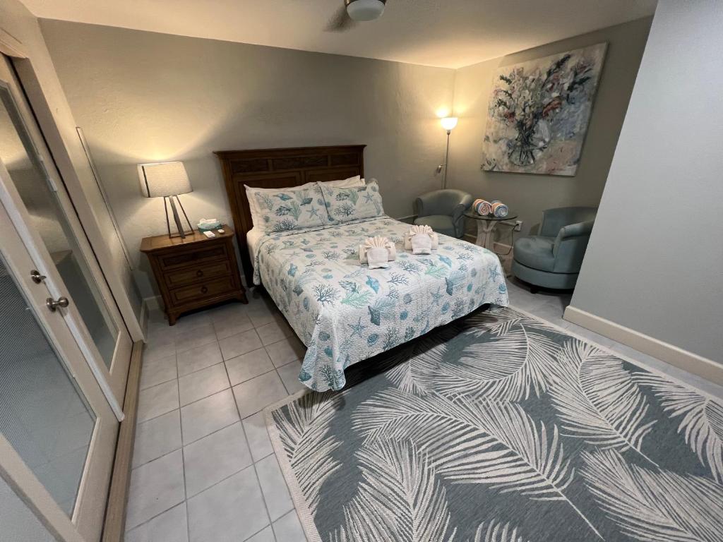 a bedroom with a bed and a table and a chair at Tarpon Tale Inn in Sanibel