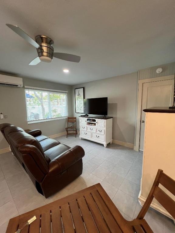 a living room with a leather couch and a television at Tarpon Tale Inn in Sanibel
