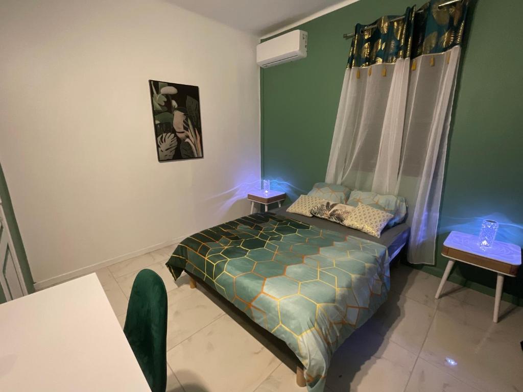 1 dormitorio con 1 cama en una habitación con paredes verdes en Résidence Peace & Joy en Fort-de-France