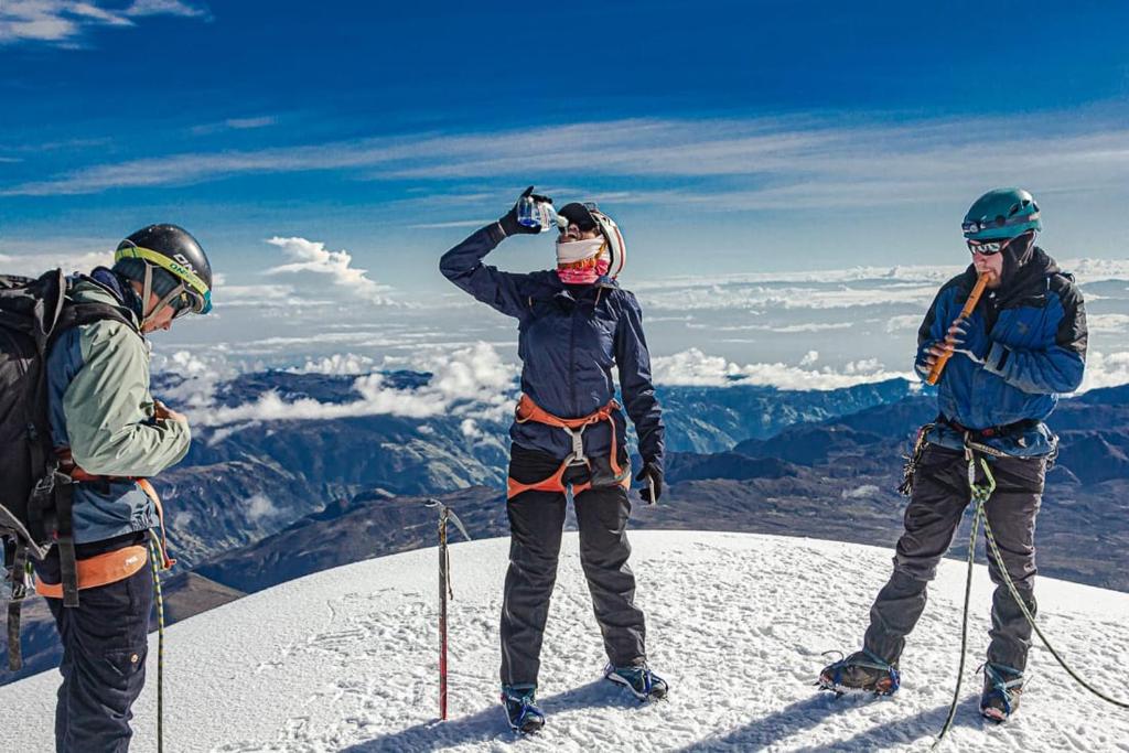 three people standing on top of a snow covered mountain at Atardecer De Salento in Salento