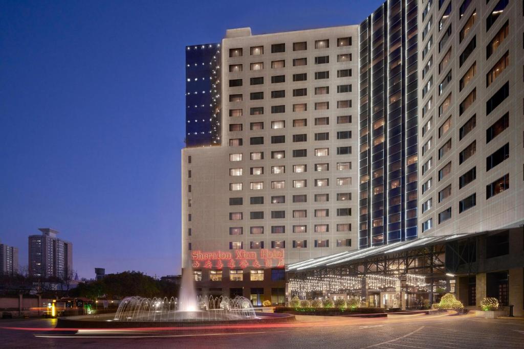 um grande edifício com uma fonte em frente em Sheraton Xi'an Hotel em Xi'an