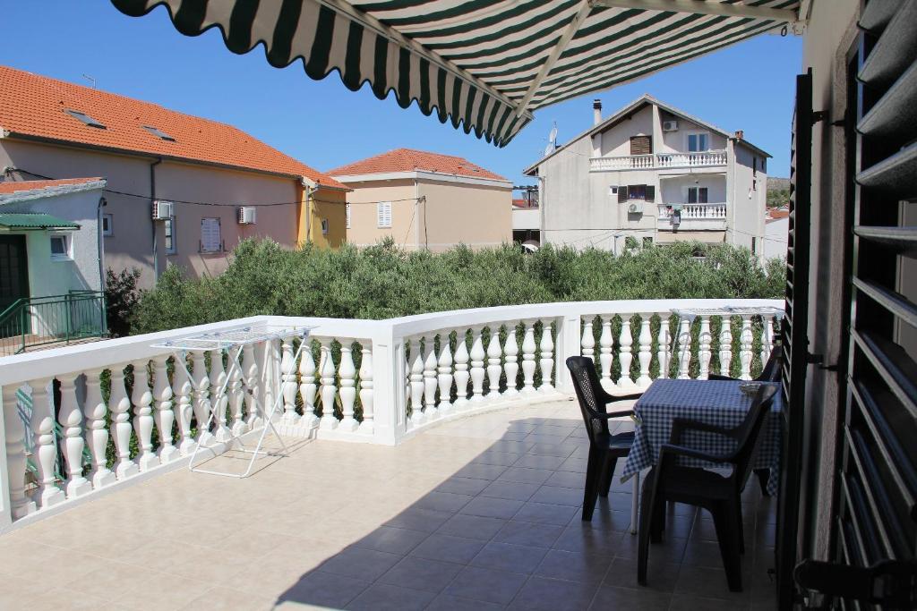 a patio with a table and chairs on a balcony at Apartments Big - free parking in Vodice