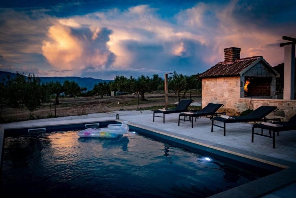una piscina con 2 sillas y una casa en Holiday home Diana - with pool, en Pučišća