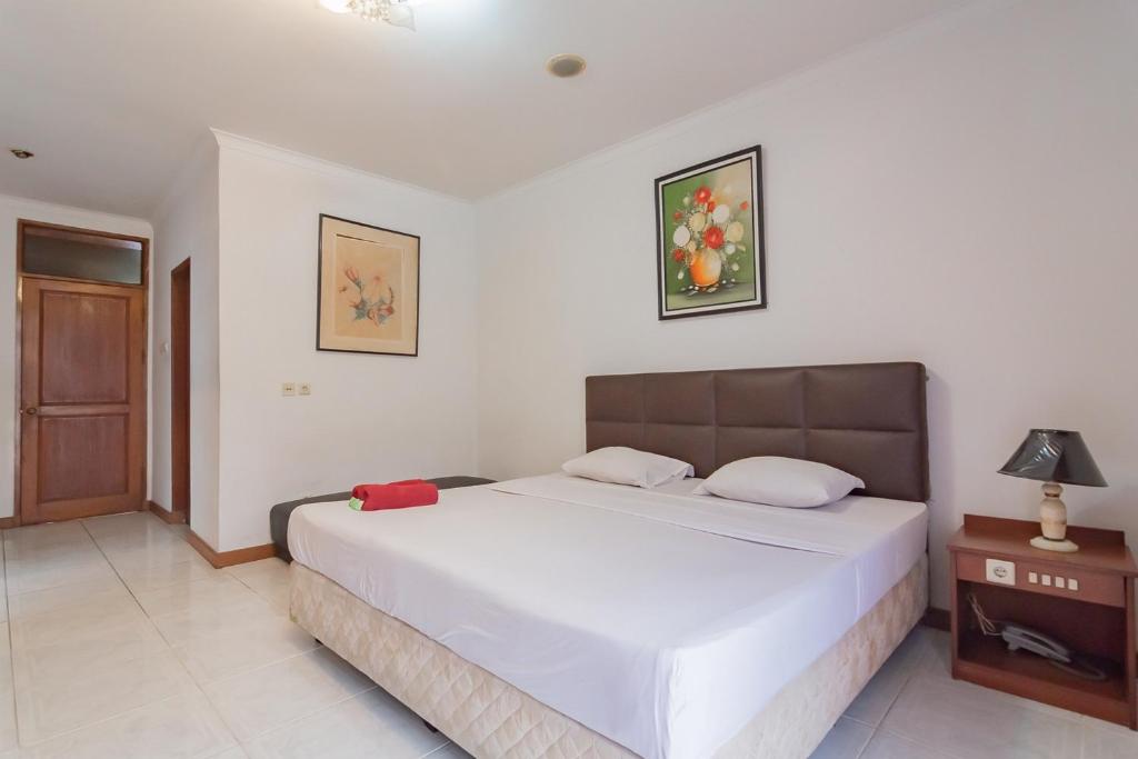 1 dormitorio con 1 cama blanca grande en una habitación en Dequr Hotel Dipati Ukur Mitra RedDoorz, en Bandung