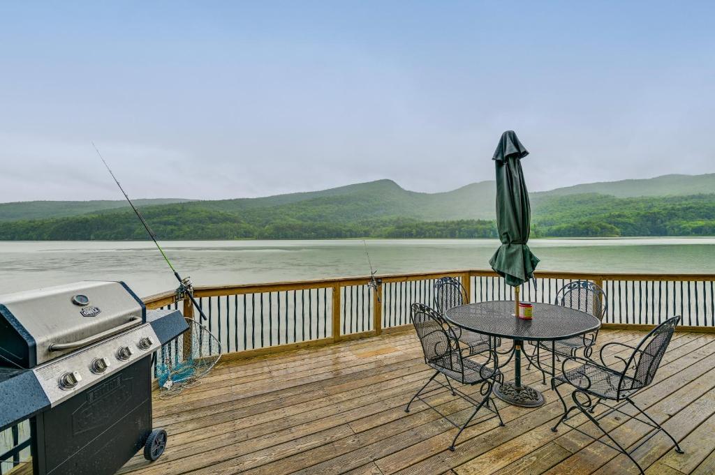 une table et des chaises sur une terrasse avec un grill dans l'établissement Cozy South Bay Cabin with Lake and Mountain Views, 