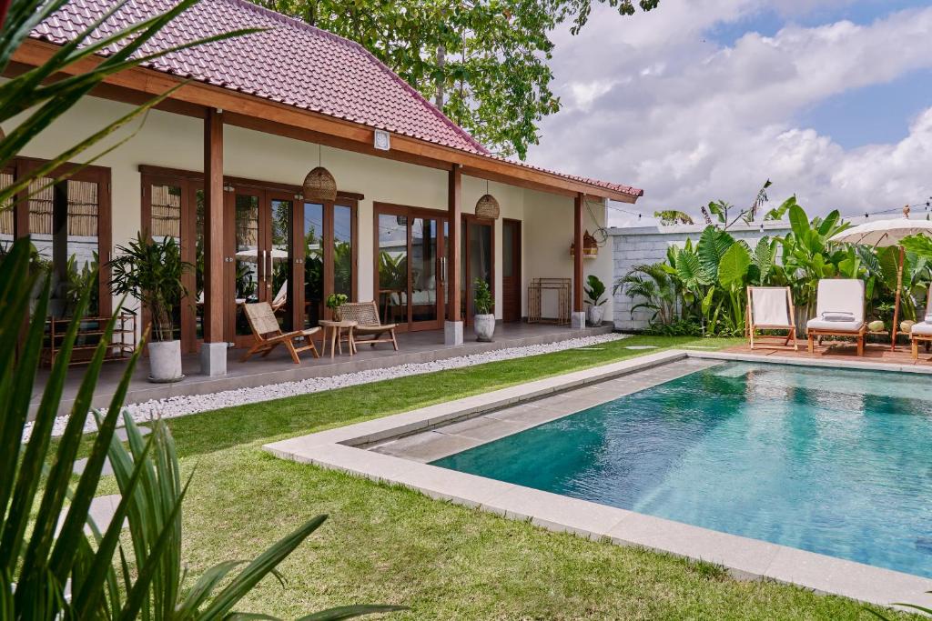 a villa with a swimming pool in front of a house at New Villa La Crema - Designer 3BR Canggu in Canggu
