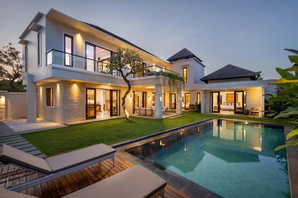 a house with a swimming pool in front of it at Villa UmaDahayu in Sanur