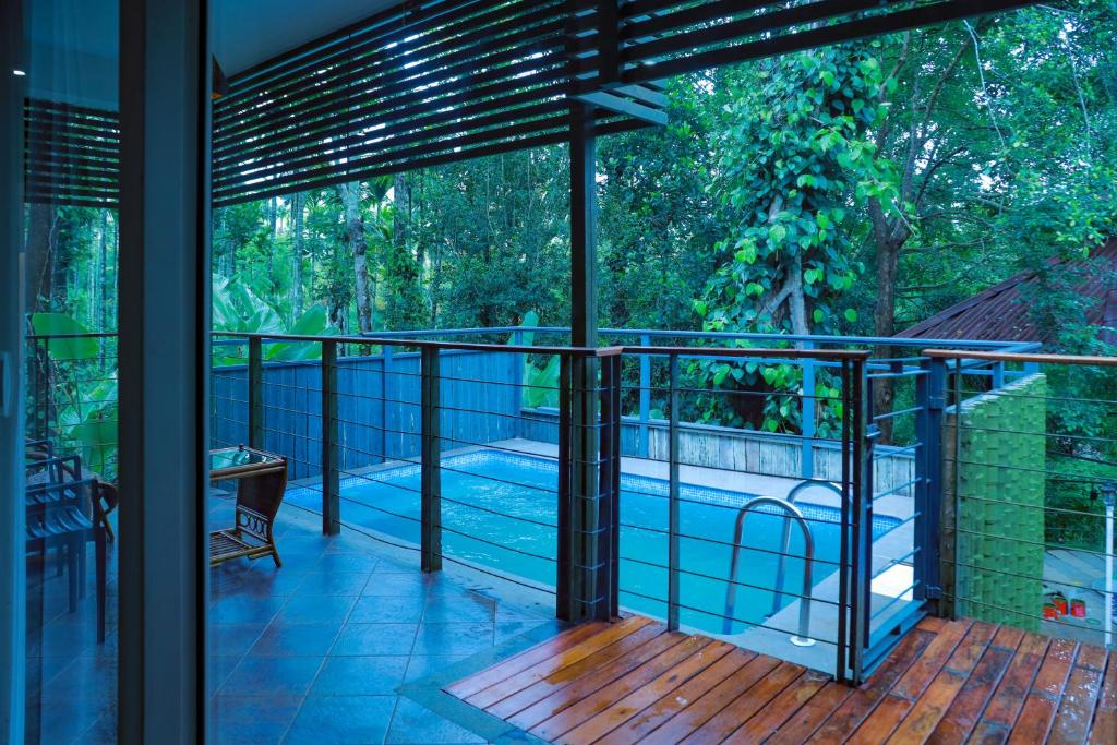 a balcony with a view of a swimming pool at Kuruva Island Resort And Spa - By KABINI BREEZE, Wayanad in Mananthavady