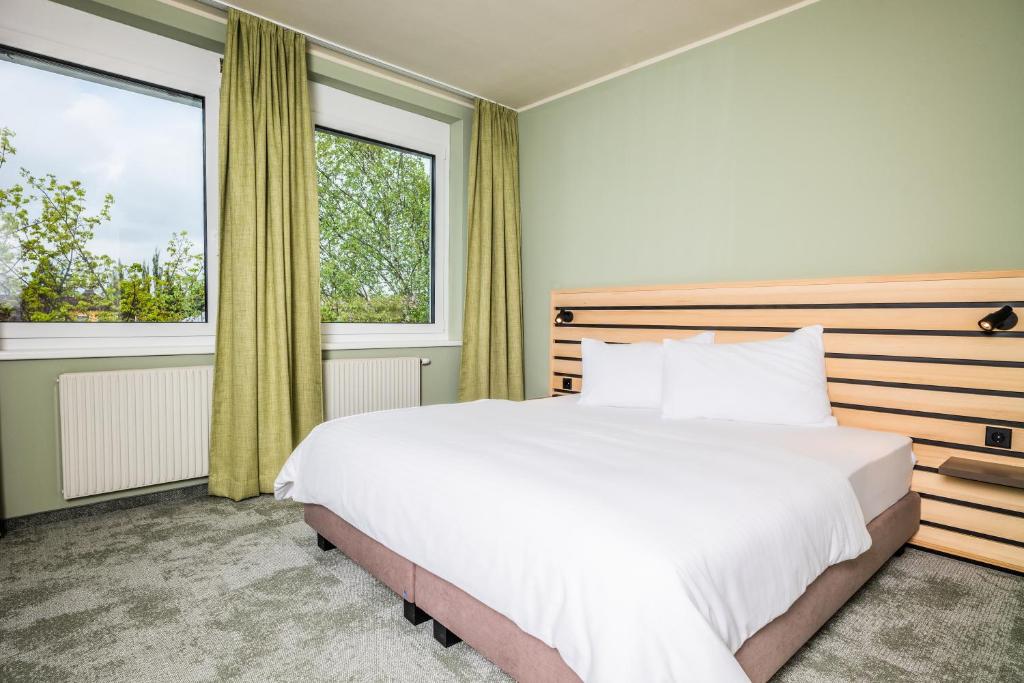 a bedroom with a large bed and two windows at flexymotel Spielberg in Spielberg