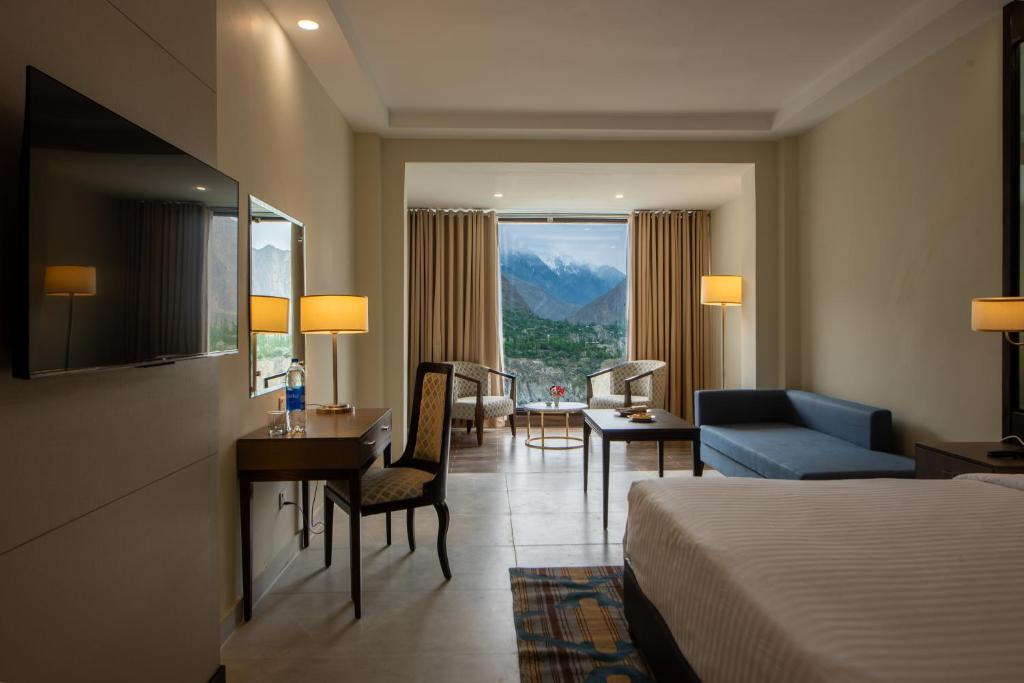 una camera d'albergo con letto, scrivania e sedia di PC Legacy Hunza a Valle dell'Hunza