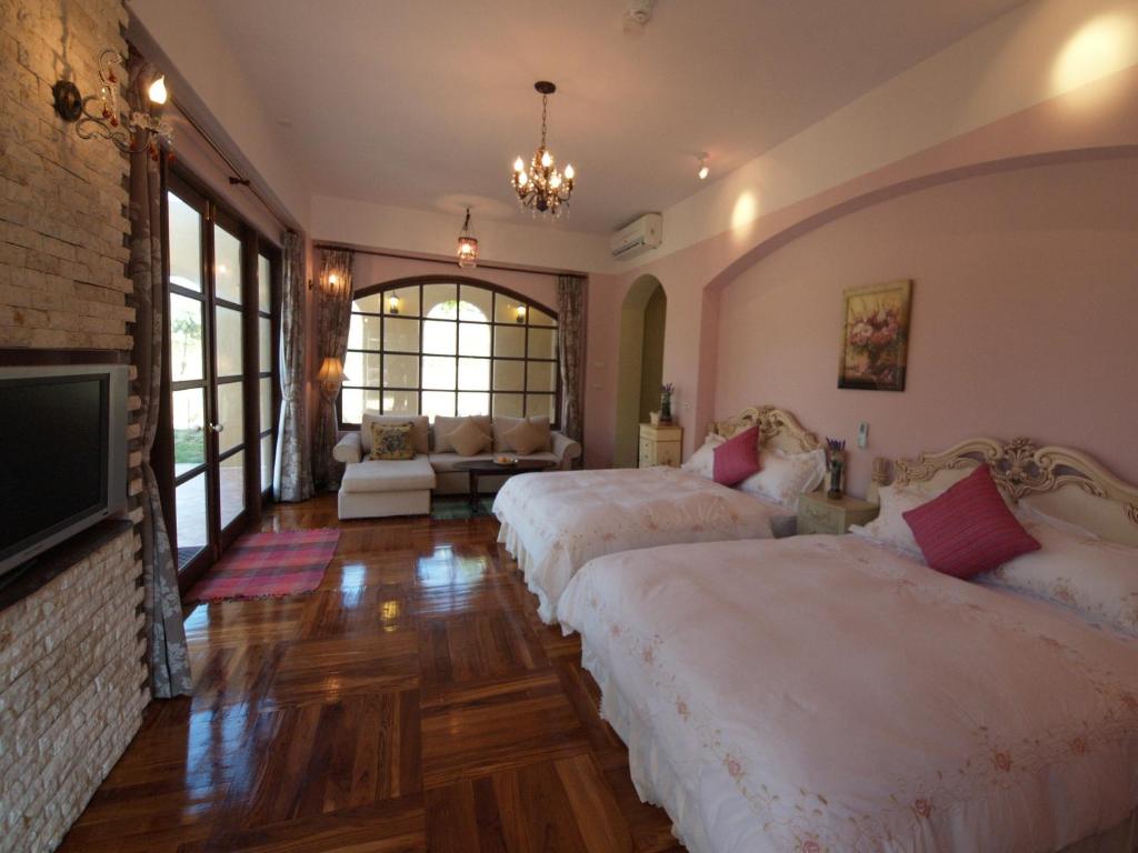 a bedroom with two beds and a living room at Kenting Tuscany Resort in Kenting