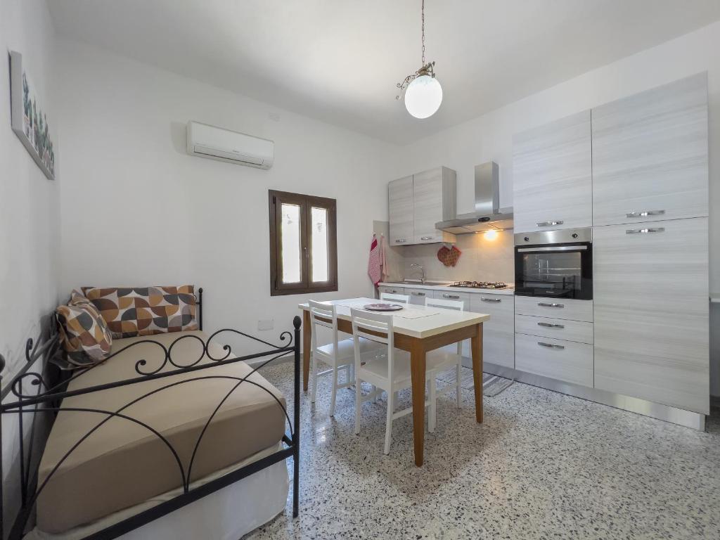 una cucina con tavolo e un letto in una camera di [Casa Vacanze Mallela] • Balcony, A/C & SmartTv a Loceri
