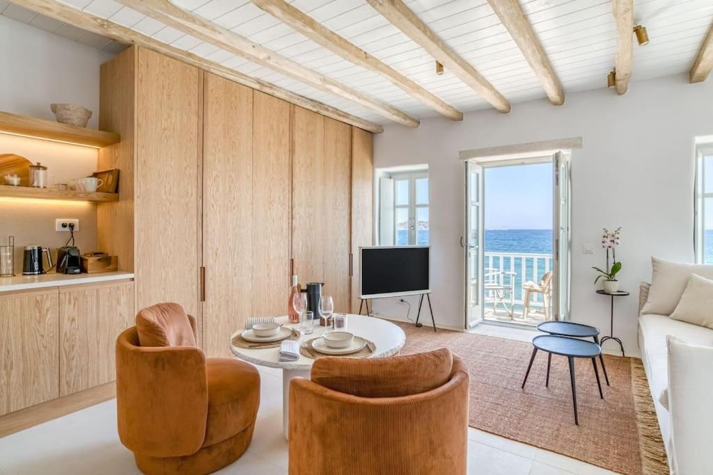 Una sala de estar con una mesa y sillas y un televisor. en Fotis House - Unique in Paros, en Naousa