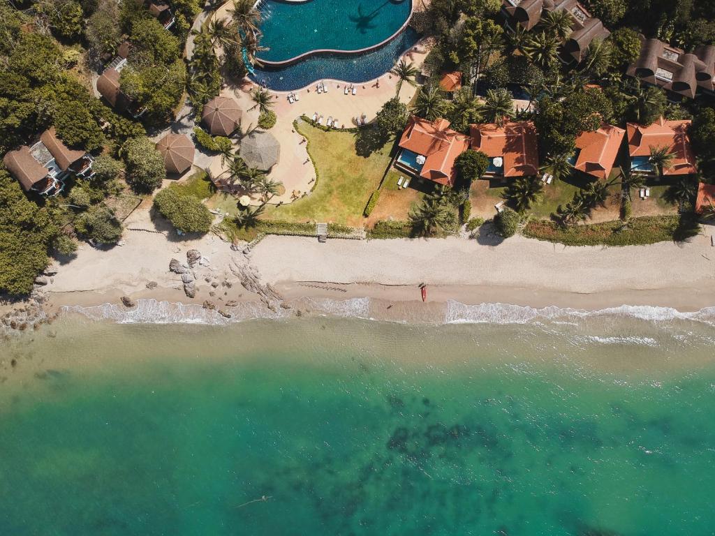 een luchtzicht op een strand met huizen en het water bij Rawi Warin Resort And Spa - SHA Extra Plus in Koh Lanta