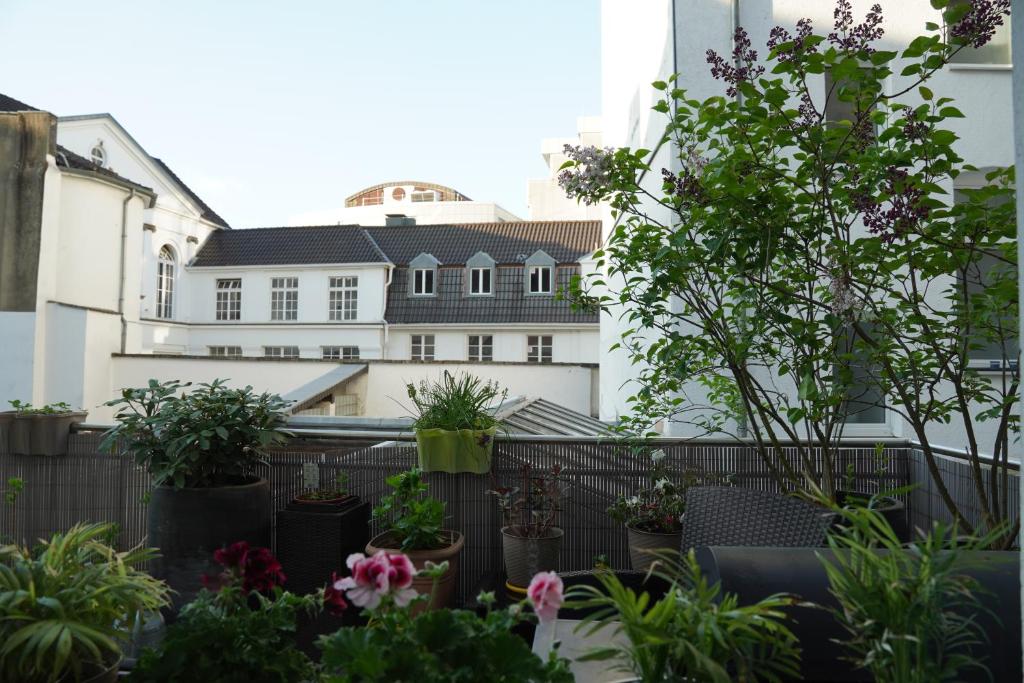 a balcony with potted plants in front of a building at Bright, spacious apartment with a lovely terrace in the heart of Aachen in Aachen