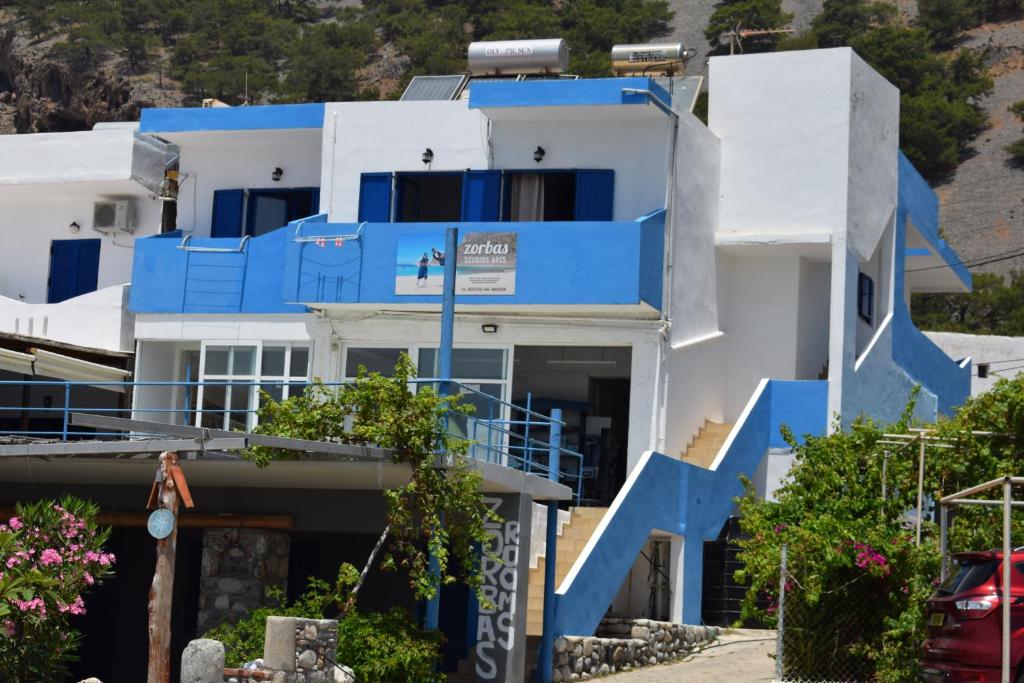 a blue and white house with blue stairs at Zorbas Studios in Agia Roumeli